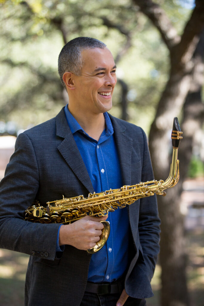 Headshot of Djamel Mami with his alto saxophone.