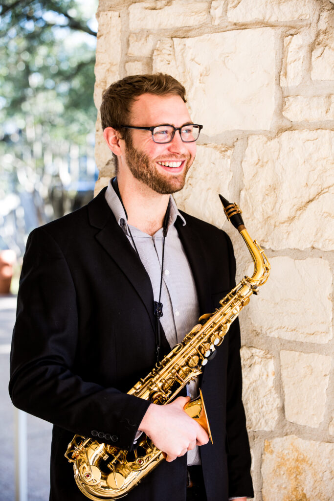 Headshot of Dustin Hunter with his alto saxophone.