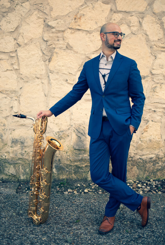 Headshot of Sunil Gadgil with his baritone saxophone.